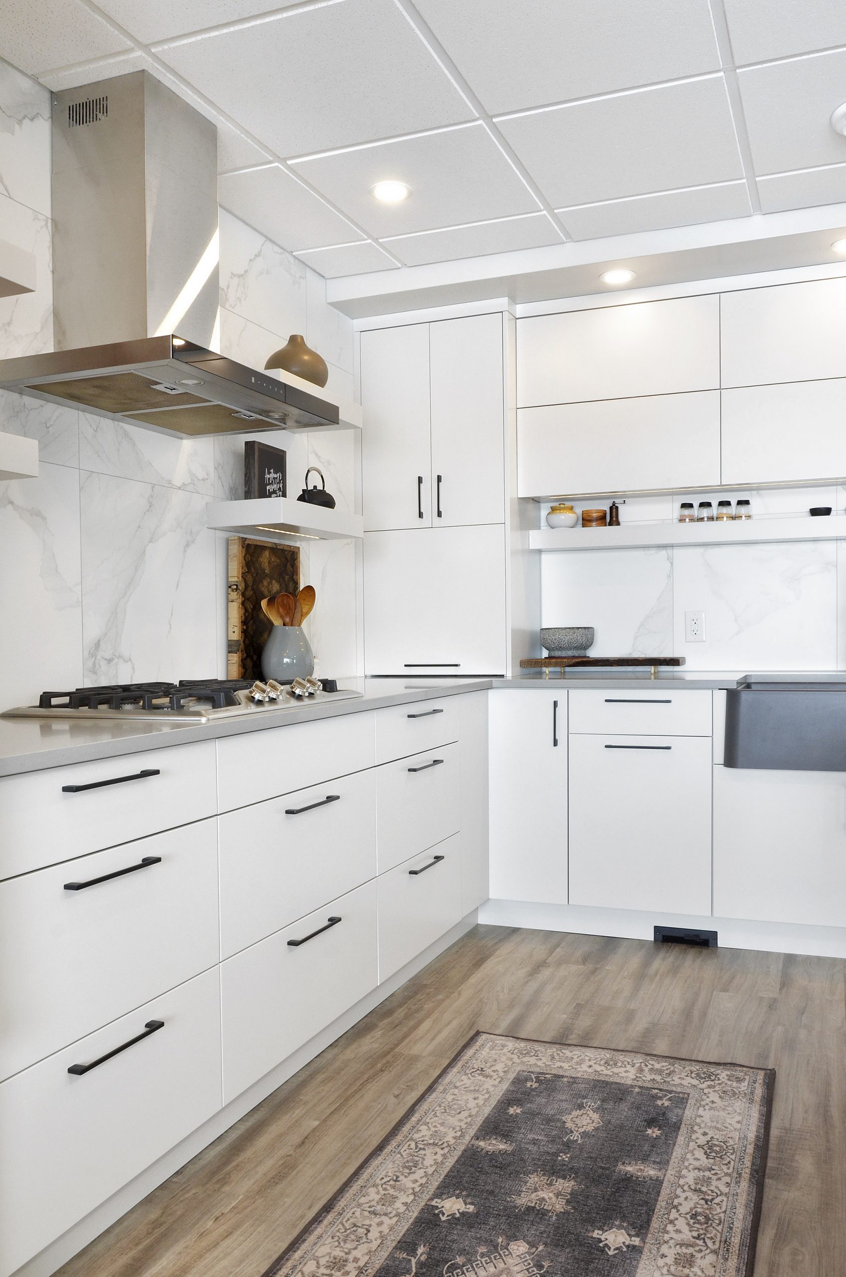Rivers Edge kitchen renovation Winnipeg island marble modern industrial finishes black drawer pulls grey wood floor