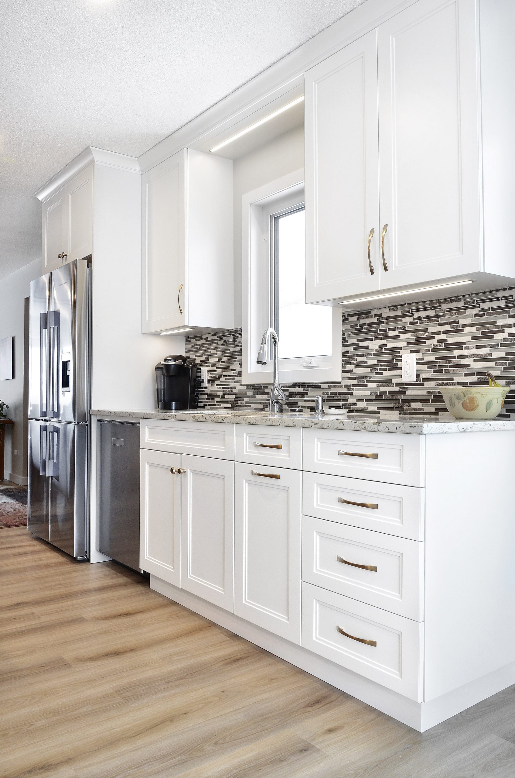 Winnipeg renovations modern kitchen sleek white cabinets white marble countertop thin tile backsplash